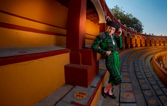 Female matador posing in a vibrant bullring dressed in traditional traje de luces.