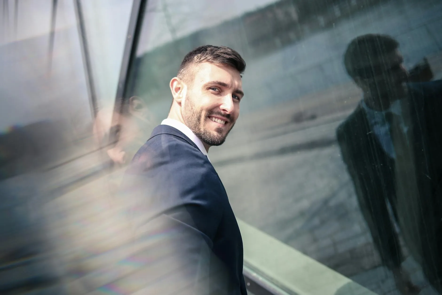 Hombre atractivo y bien vestido sonriendo en un entorno social con confianza.
