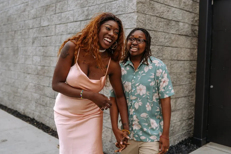 Happy couple standing outdoors, laughing and holding hands, showcasing love and joy.