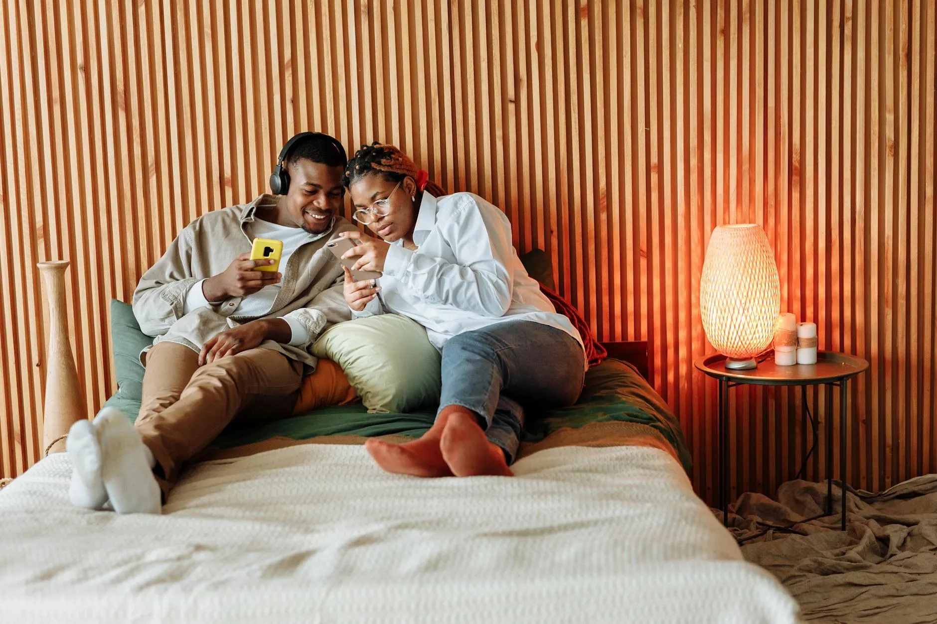 Pareja sonriendo mientras conversa por mensaje de texto, mostrando conexión.