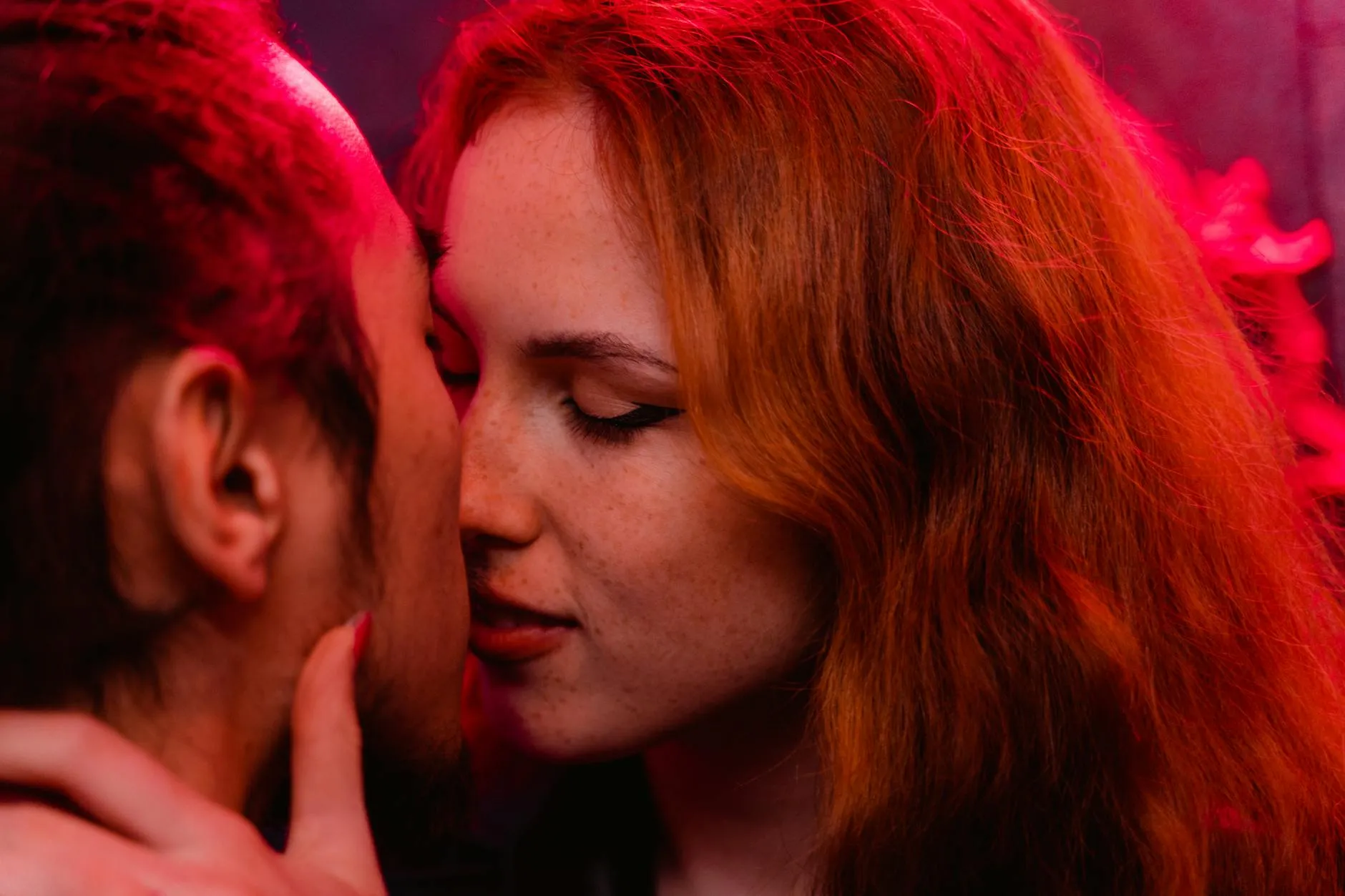 Pareja muy cerca, compartiendo un momento íntimo previo al primer beso.