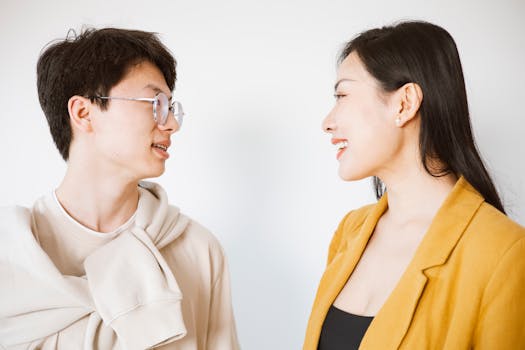 Smiling man and woman having a friendly conversation in a bright indoor setting.