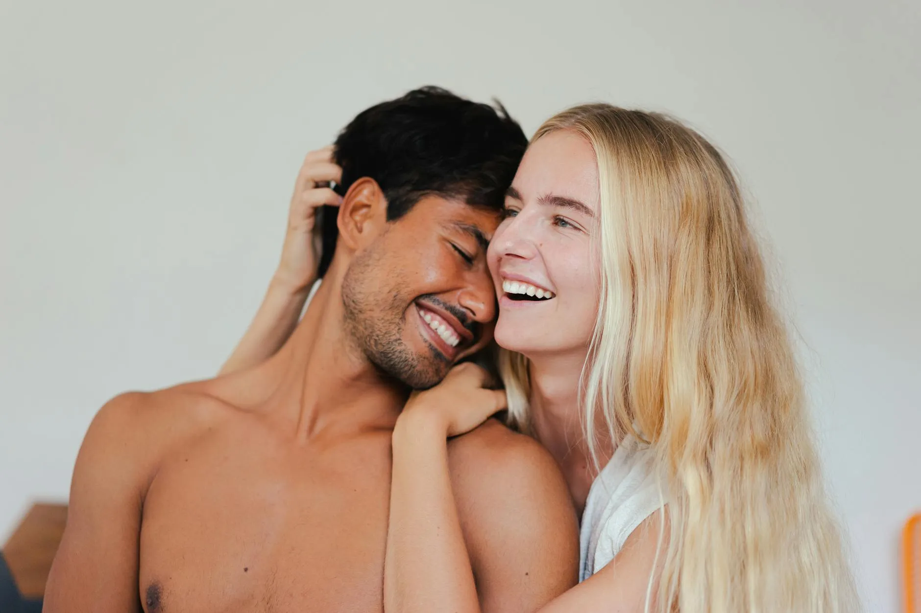 Pareja riendo juntos espontaneamente, mostrando fuerte quimica y conexion natural.